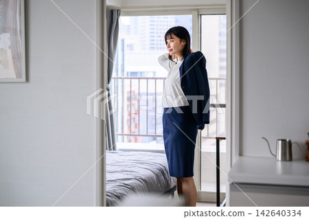 A woman in a suit, getting ready for a new day. A woman in a suit, getting ready for a new day. 142640334