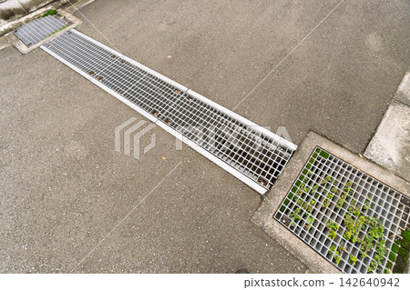 Drainage ditch crossing a road; residential street Drainage ditch crossing a road; residential street 142640942