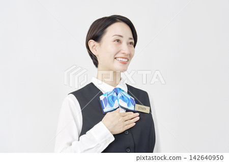 女性工作人員，手放在胸前；接待員/銀行職員；白色背景；肖像照。 142640950