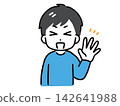 A young man in casual clothes is smiling and raising one hand. 142641988