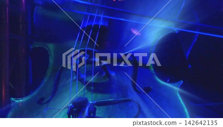 Lighting cue starting wooden cello body gleaming under blue teal stage lights, showing f-holes 142642135