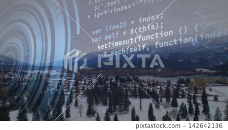 Rising drone capturing snowy valley town, revealing homes, river, peaks, code overlay, ring graphic 142642136