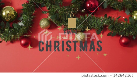 Featuring evergreen garland, holly and tinsel on red backdrop, showing printed greeting and baubles Featuring evergreen garland, holly and tinsel on red backdrop, showing printed greeting and baubles 142642165
