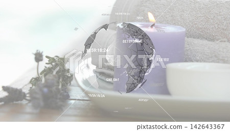 Floating translucent 3D globe graphic showing overlays on wooden tabletop, with lavender and candle Floating translucent 3D globe graphic showing overlays on wooden tabletop, with lavender and candle 142643367
