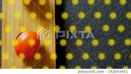 Resting red cherry tomato on vertical grain board at kitchen counter, yellow burst grid, copy space 142643451
