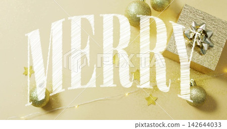 Displaying large white 'MERRY' lettering on gold tabletop with gold baubles, present, string lights Displaying large white 'MERRY' lettering on gold tabletop with gold baubles, present, string lights 142644033
