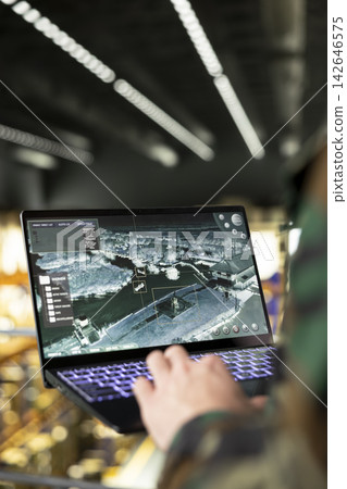Close up, military personnel, operational activities, military base warehouse, reviewing real-time surveillance systems on digital interface. Supply chain management and intelligence oversight. Close up, military personnel, operational activities, military base warehouse, reviewing real-time surveillance systems on digital interface. Supply chain management and intelligence oversight. 142646575
