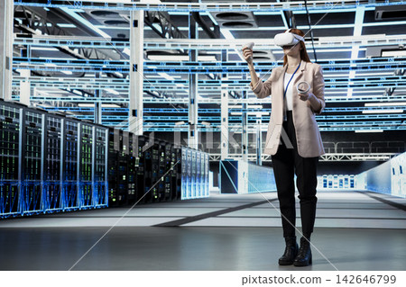 Data center admin using VR headset gear to install and upgrade server racks systems. Server room engineer using virtual reality tech application to monitor infrastructure performance 142646799