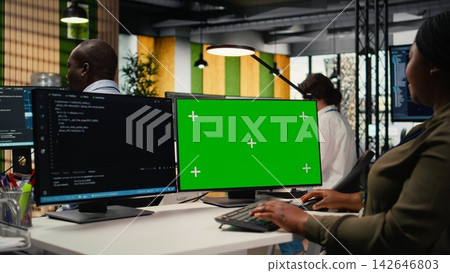 Green screen computer used by admin in office doing software development to launch new features. Mockup PC used by woman in startup company writing computer programs, doing code, camera A 142646803