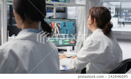Medical laboratory technician checking time, waiting to finish shift, processing patient data. Research facility worker using PC to do genetic analysis diagnostics checking wrist watch clock, camera B Medical laboratory technician checking time, waiting to finish shift, processing patient data. Research facility worker using PC to do genetic analysis diagnostics checking wrist watch clock, camera B 142646895