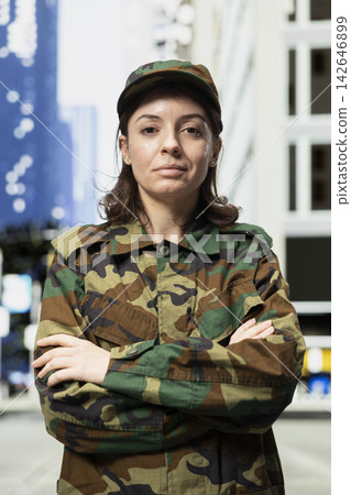 Serving in army, crossed arms and portrait of proud soldier protecting citizens. Defending city landmarks, camouflage uniform and female military officer prepared for combat Serving in army, crossed arms and portrait of proud soldier protecting citizens. Defending city landmarks, camouflage uniform and female military officer prepared for combat 142646899