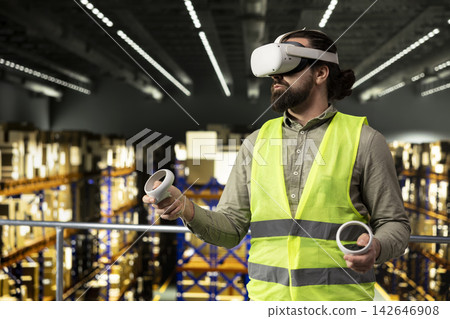 Male warehouse employee, using VR headset, simulation software, supporting delivery and supply chain management. Industrial AI technology helping with cargo shipment in facility. Male warehouse employee, using VR headset, simulation software, supporting delivery and supply chain management. Industrial AI technology helping with cargo shipment in facility. 142646908