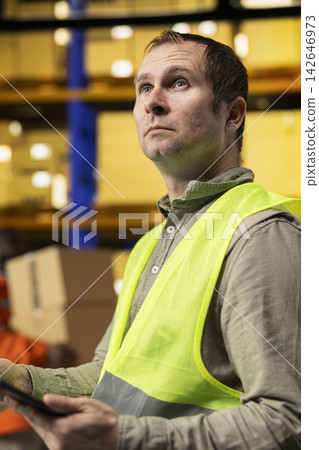 Staff organizing packages on tablet based on shipment details in fulfillment center. Shipping accuracy and efficiency improves barcode tracking technology and warehouse workforce operations. Staff organizing packages on tablet based on shipment details in fulfillment center. Shipping accuracy and efficiency improves barcode tracking technology and warehouse workforce operations. 142646973