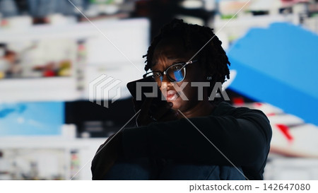 Young woman browsing internet using laptop, watching content on video streaming services. African american teenager looking at entertaining VOD broadcasts online using notebook, camera B Young woman browsing internet using laptop, watching content on video streaming services. African american teenager looking at entertaining VOD broadcasts online using notebook, camera B 142647080