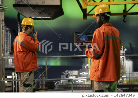 African american male engineer uses AI machine learning tools on laptop for drilling rig activity, artificial intelligence to support efficient natural gas extraction from marine habitat. African american male engineer uses AI machine learning tools on laptop for drilling rig activity, artificial intelligence to support efficient natural gas extraction from marine habitat. 142647349