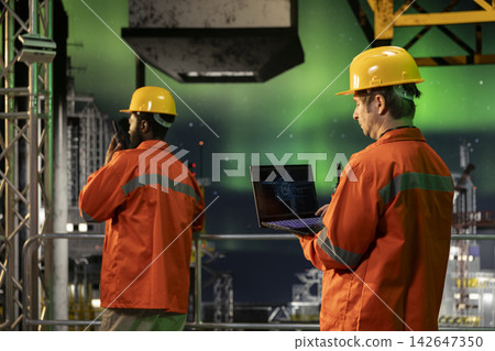 Offshore industrial worker uses AI machine learning tools on laptop for drilling rig operations, artificial intelligence to support safe oil and gas extraction activity from ocean habitat. Offshore industrial worker uses AI machine learning tools on laptop for drilling rig operations, artificial intelligence to support safe oil and gas extraction activity from ocean habitat. 142647350