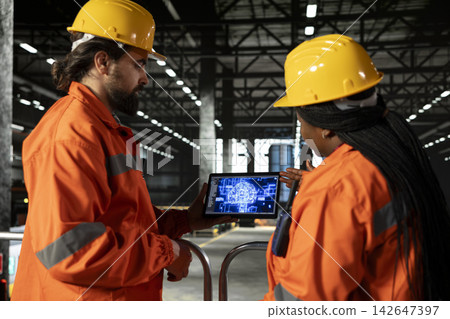 Engineers team analyzes AI brain interface inside heavy industry factory warehouse, AI-powered visualization uses machine learning and cloud computing to optimize the manufacturing process. Engineers team analyzes AI brain interface inside heavy industry factory warehouse, AI-powered visualization uses machine learning and cloud computing to optimize the manufacturing process. 142647397
