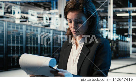 Verifying infrastructure status, clipboard files and manager in data center with holographic visuals. Overseeing equipment, wireframe simulation and worker in server room using audit charts Verifying infrastructure status, clipboard files and manager in data center with holographic visuals. Overseeing equipment, wireframe simulation and worker in server room using audit charts 142647419