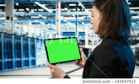Isolated screen tablet in data center used by software developer to conduct security audit on IT infrastructure. Chroma key device in server hub used by worker to verify firewall protection Isolated screen tablet in data center used by software developer to conduct security audit on IT infrastructure. Chroma key device in server hub used by worker to verify firewall protection 142647422