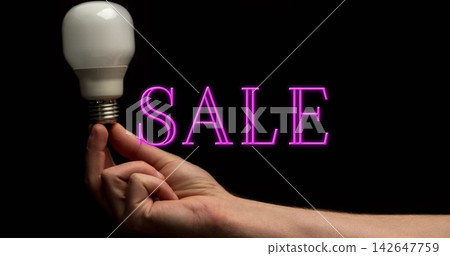 Extending forearm and hand from right edge in studio, holding LED bulb, magenta SALE neon glowing Extending forearm and hand from right edge in studio, holding LED bulb, magenta SALE neon glowing 142647759