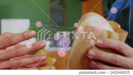 Handing two adult hands exchanging wrapped sandwich at cafe counter, with network overlay 142648055