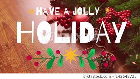 Showing white HOLIDAY and HAVE JOLLY text on wood-grain tabletop, evergreen sprigs, red ornament Showing white HOLIDAY and HAVE JOLLY text on wood-grain tabletop, evergreen sprigs, red ornament 142648725