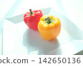 Red and yellow bell peppers on a white plate 142650136