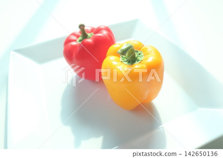 Red and yellow bell peppers on a white plate Red and yellow bell peppers on a white plate 142650136