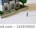 A businessman gazing at a model house | Image of real estate consideration and property viewing 142650602