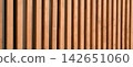 Warm wooden backdrop features vertical slats with natural grain 142651060