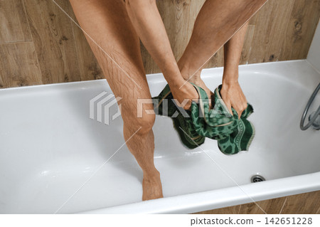 Person drying feet with towel after shower in bathroom Person drying feet with towel after shower in bathroom 142651228