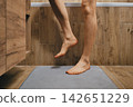 Male feet stepping onto mat in home bathroom at morning 142651229