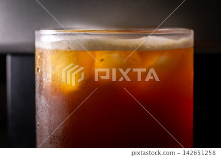 咖啡機將咖啡注入透明冰玻璃杯,在時間的光影中呈現永恆的冰淇淋、咖啡油和暖色光影。 咖啡機將咖啡注入透明冰玻璃杯,在時間的光影中呈現永恆的冰淇淋、咖啡油和暖色光影。 142651258
