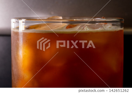 咖啡機將咖啡注入透明冰玻璃杯,在時間的光影中呈現永恆的冰淇淋、咖啡油和暖色光影。 咖啡機將咖啡注入透明冰玻璃杯,在時間的光影中呈現永恆的冰淇淋、咖啡油和暖色光影。 142651262