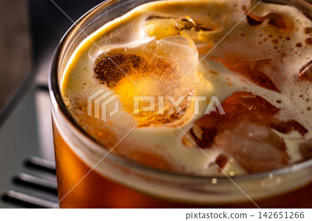 咖啡機將咖啡注入透明冰玻璃杯,在時間的光影中呈現永恆的冰淇淋、咖啡油和暖色光影。 咖啡機將咖啡注入透明冰玻璃杯,在時間的光影中呈現永恆的冰淇淋、咖啡油和暖色光影。 142651266