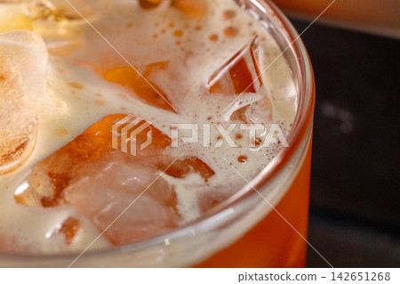 咖啡機將咖啡注入透明冰玻璃杯,在時間的光影中呈現永恆的冰淇淋、咖啡油和暖色光影。 咖啡機將咖啡注入透明冰玻璃杯,在時間的光影中呈現永恆的冰淇淋、咖啡油和暖色光影。 142651268