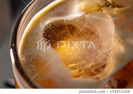 咖啡機將咖啡注入透明冰玻璃杯,在時間的光影中呈現永恆的冰淇淋、咖啡油和暖色光影。 咖啡機將咖啡注入透明冰玻璃杯,在時間的光影中呈現永恆的冰淇淋、咖啡油和暖色光影。 142651269