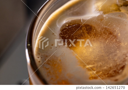 咖啡機將咖啡注入透明冰玻璃杯,在時間的光影中呈現永恆的冰淇淋、咖啡油和暖色光影。 咖啡機將咖啡注入透明冰玻璃杯,在時間的光影中呈現永恆的冰淇淋、咖啡油和暖色光影。 142651270