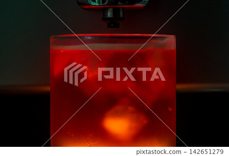 咖啡機將咖啡注入透明冰玻璃杯,在時間的光影中呈現永恆的冰淇淋、咖啡油和暖色光影。 咖啡機將咖啡注入透明冰玻璃杯,在時間的光影中呈現永恆的冰淇淋、咖啡油和暖色光影。 142651279