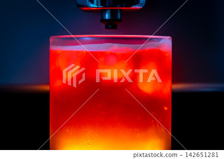 咖啡機將咖啡注入透明冰玻璃杯,在時間的光影中呈現永恆的冰淇淋、咖啡油和暖色光影。 咖啡機將咖啡注入透明冰玻璃杯,在時間的光影中呈現永恆的冰淇淋、咖啡油和暖色光影。 142651281