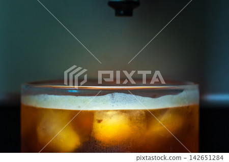 咖啡機將咖啡注入透明冰玻璃杯,在時間的光影中呈現永恆的冰淇淋、咖啡油和暖色光影。 咖啡機將咖啡注入透明冰玻璃杯,在時間的光影中呈現永恆的冰淇淋、咖啡油和暖色光影。 142651284