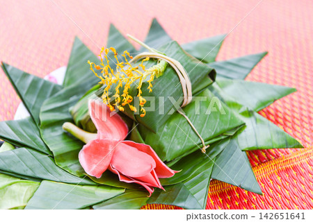 dessert thai food wrap with banana leaf and flowers on tray 142651641