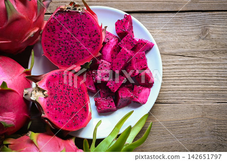 dragon fruit slice and cut half on white plate with pitahaya background, fresh pink red purple dragon fruit tropical in the asian thailand healthy fruit concept dragon fruit slice and cut half on white plate with pitahaya background, fresh pink red purple dragon fruit tropical in the asian thailand healthy fruit concept 142651797