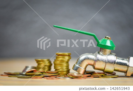 faucet on money coin wood background / water savings and faucet money fall faucet on money coin wood background / water savings and faucet money fall 142651943