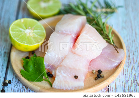Fish fillet on wooden plate with ingredients celery for cookin, fresh raw pangasius fish fillet with lemon lime, meat dolly fish tilapia striped catfish 142651965