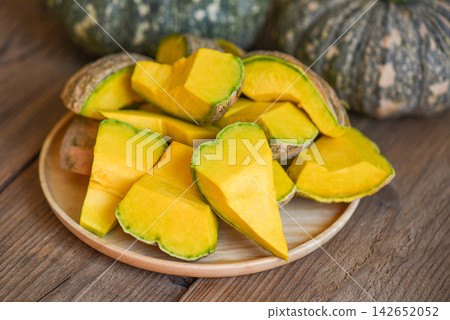 fresh Asian Thai pumpkin frome the garden for cooked food or dessert, chopped pumpkin, green pumpkin food on wooden cutting board background fresh Asian Thai pumpkin frome the garden for cooked food or dessert, chopped pumpkin, green pumpkin food on wooden cutting board background 142652052
