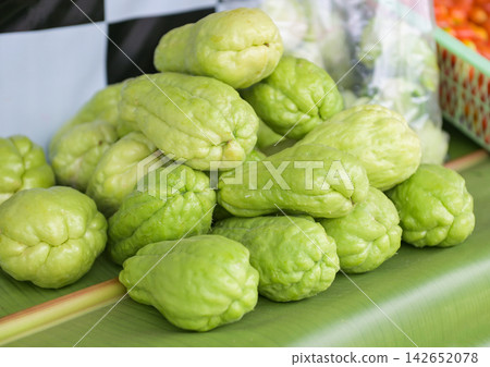 Fresh chayote fruits (Sechium edulis) on leaf background, Chayote or sweet gourd - Cucurbitaceae 142652078