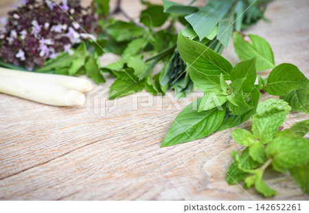 Fresh herbs and spices with sweet basil lemon grass holy basil peppermint leaf on wooden background - ingredient asian food Fresh herbs and spices with sweet basil lemon grass holy basil peppermint leaf on wooden background - ingredient asian food 142652261