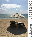 A holiday spent on the beach and under a beach umbrella at a tropical resort. 142652400