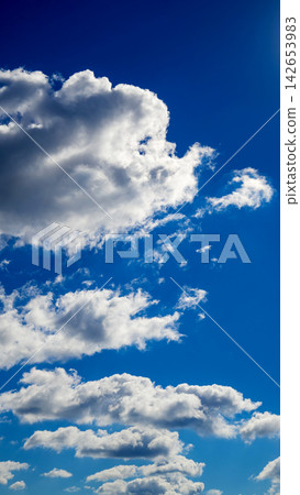 vertical view of tiered cumulus clouds in a blue sky space vertical view of tiered cumulus clouds in a blue sky space 142653983